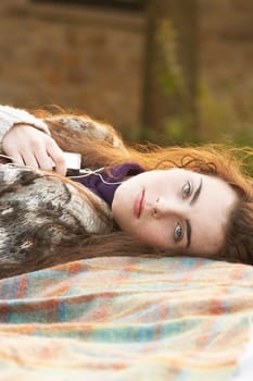 Portrait Of Beautiful Teenage Girl Outdoors Listening To MP3 Player In Autumn Landscape