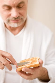 Senior mature man having breakfast toast