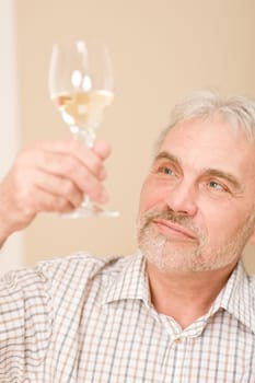 Senior mature man with glass of white wine