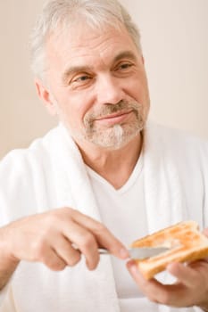 Senior mature man having breakfast toast