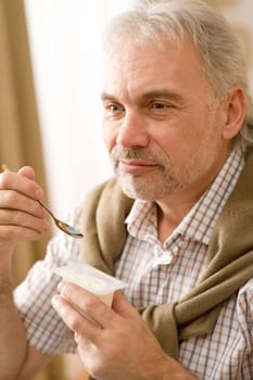 Senior mature man eat yogurt snack