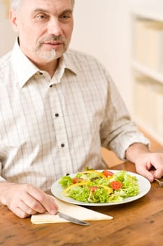 Senior mature man eat vegetable salad