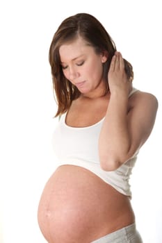 Pregnant,young woman in front of white background looking happily at her belly