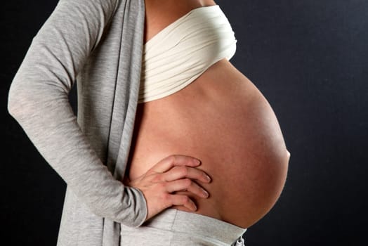 Heavily pregnant woman with a big belly,photographed sideways - copy space