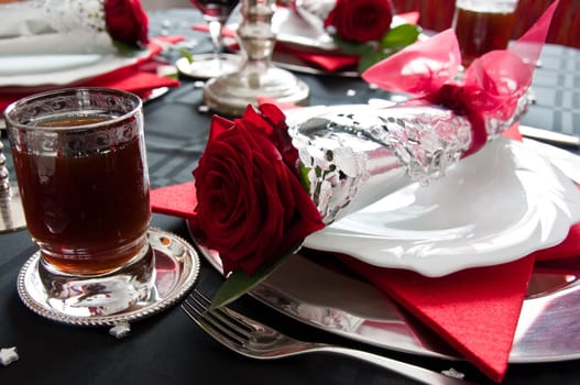 Festive table setting for Christmas with silver and red rose decoration