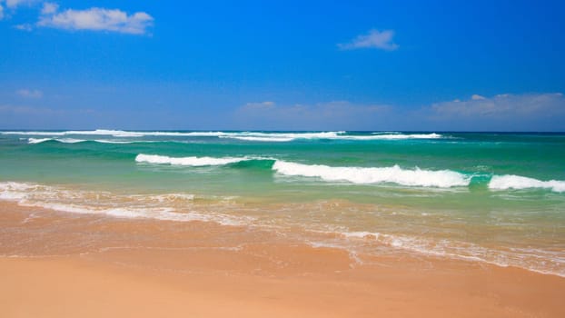 Peaceful beach scene with ocean and blue sky