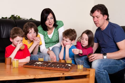 Big family is playing a boardgame in the livingroom