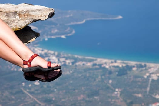 Woman with trekking sandals sitting on rock