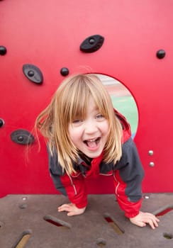 child in playground happy smiling. pretty blond boy with long hair full of joy. Childhood image of play