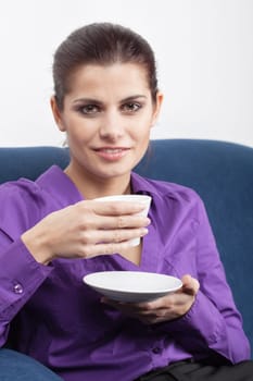 Pretty young businesswoman having a coffee break in the office