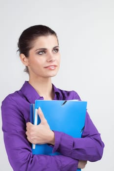 Pretty young brunette woman holding colorful plastic folders