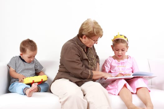 Grandma helping girl by reading and playing with baby