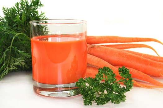 a glass of carrot juice with fresh ingredients