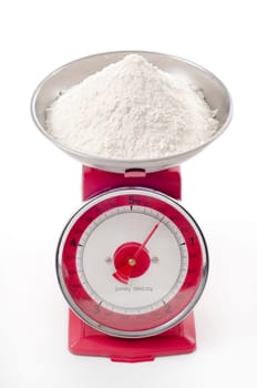 plain flour on red metal weighing scales