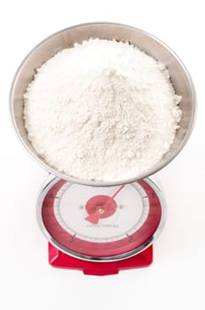 plain flour on red metal weighing scales