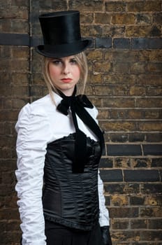 Portrait of beautiful woman in late victorian costume against brick wall