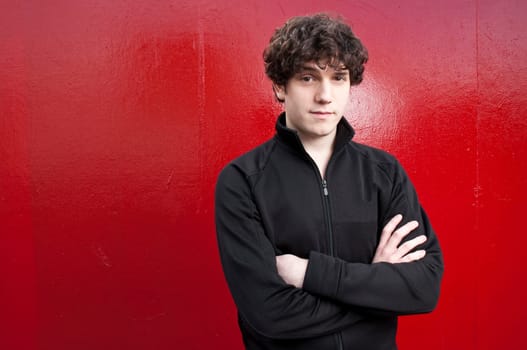 Portrait of young man looking into the camera with red background
