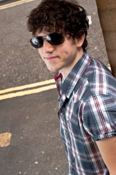 High angle street portrait of young man wearing sun glasses