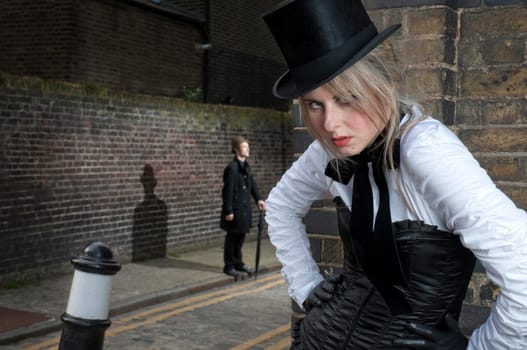 Street Fashion shot of woman in late victorian clothes with man in the background.