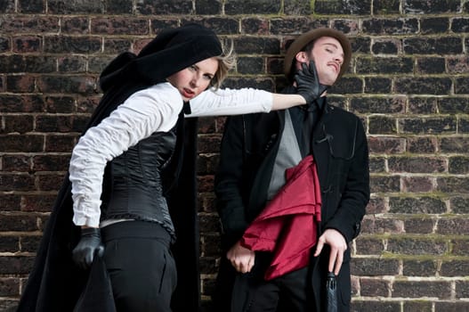 Couple in victorian costumes, woman strangling man.