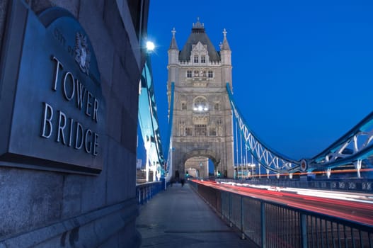 Detail of Tower Bridge in London at dusk with car light trail.