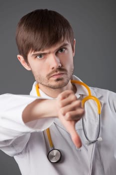 unhappy male doctor with thumbs down sign