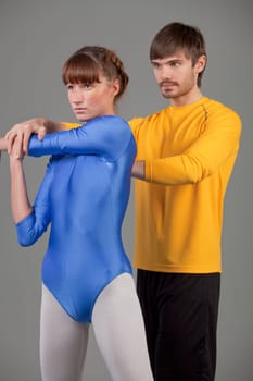 personal trainer helping young woman by sport exercises