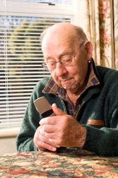 Senior man texting and calling with mobile phone