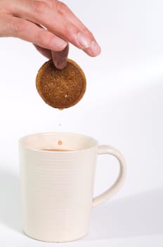 Ginger biscuit being dipped in tea