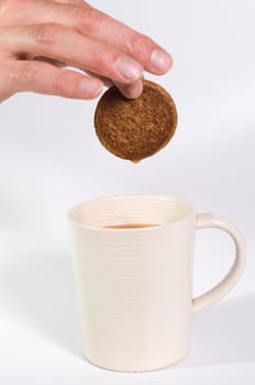 Ginger biscuit being dipped in tea