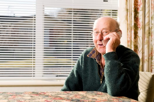 Senior man texting and calling with mobile phone