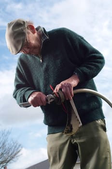 senior man fixing lawn trimmer