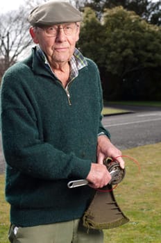 senior man fixing lawn trimmer