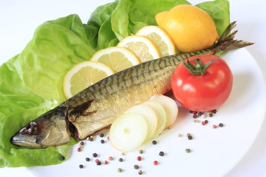 Smoked mackerel decorated with lemon on lettuce leaves