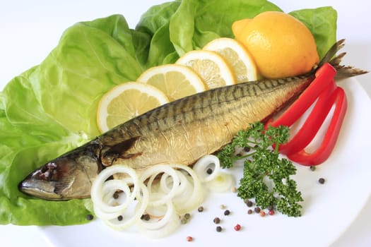 Smoked mackerel decorated with lemon on lettuce leaves