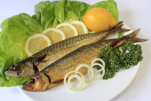 Smoked fish served on lettuce leaves with various side dishes