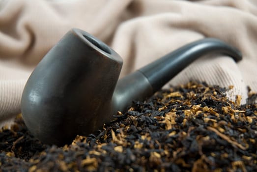 Close up shot of an Ucranian wooden pipe resting on top of tobacco.