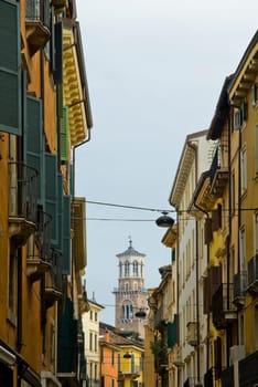 Perspective shot of top half of buildings in Verona, with Lamberti Tower in the far background.