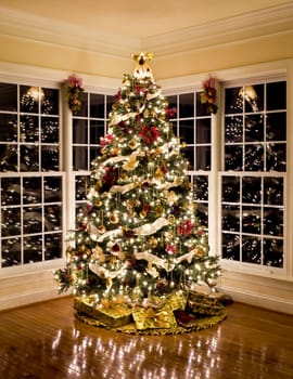 Christmas tree with presents and lights reflecting in windows around the tree in modern home