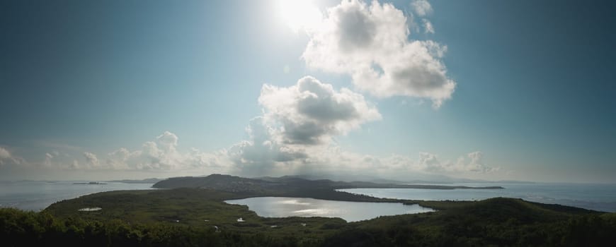 View across a lagoon towards El Yunque across with the distant rain falling on the rain forest