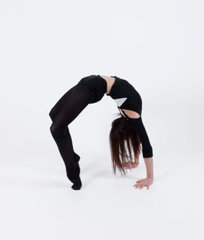 Young gymnast in black practicing in studio