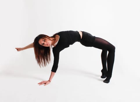 Young gymnast in black practicing in studio
