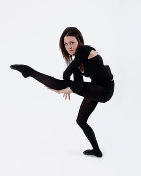 Young gymnast in black practicing in studio