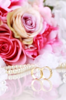 Wedding still life with beautiful golden rings and bouquet