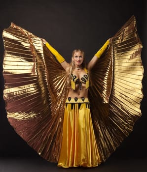 Beauty mature woman dance with gold wing arabian style