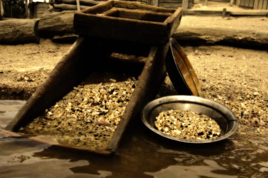 old heritage gold shaker and pan in the waters edge