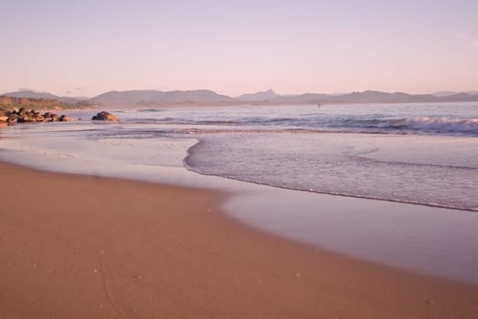 the waves are gently coming in on the tropical sandy beach
