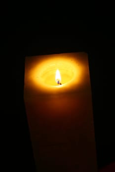Close-up candle illuminates the darkness of the night environment