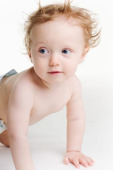 Cute baby in diaper crawling on white