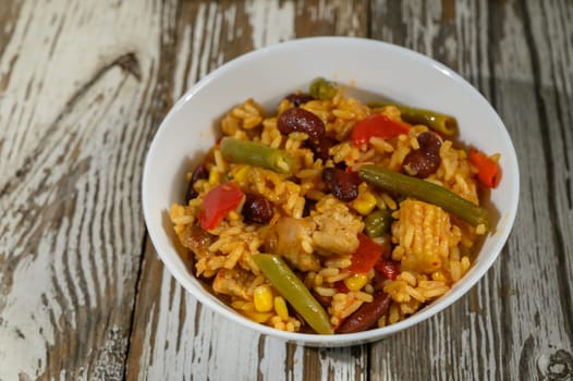 A hearty bowl filled with vibrant rice, beans, and succulent chicken, showcasing appetizing colors and textures.